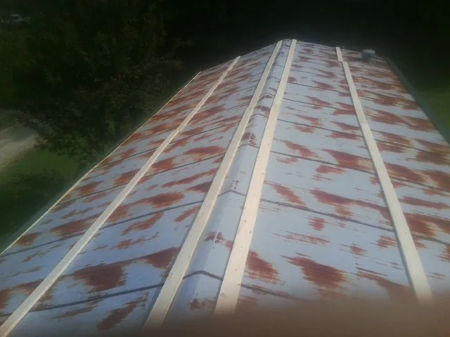 Rusted metal roof panels with new wood purlins before replacement — Storm Damage Roof Repair in Westfall by Roofing Brothers