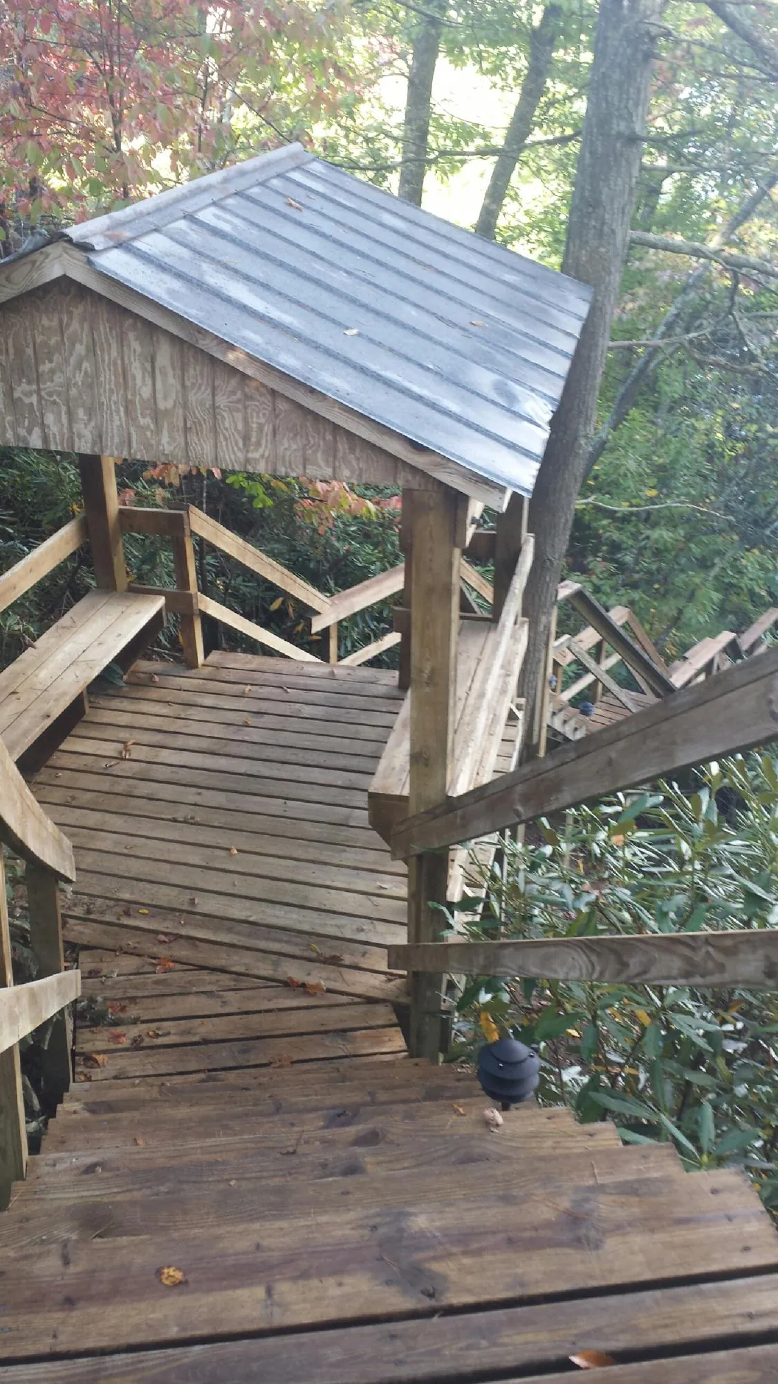 Metal roofed shelter over wooden steps on a wooded walkway — Skylight Repair & Installation work by our crew in Westfall