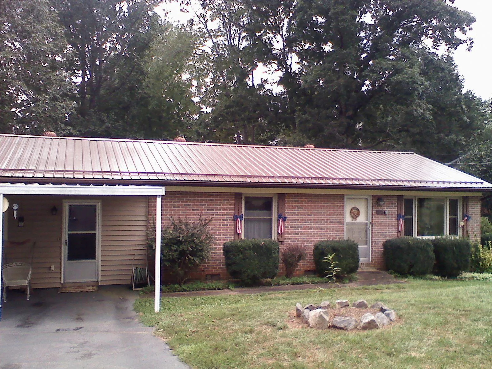 Bronze metal roof and carport on a brick ranch home — Roof Repair work by our crew in Westfall